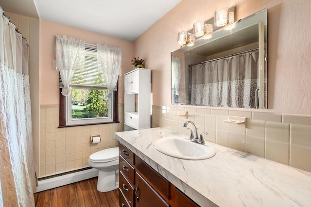 full bathroom with vanity, wood finished floors, toilet, tile walls, and baseboard heating