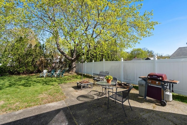 view of patio / terrace featuring area for grilling, fence, and a fire pit
