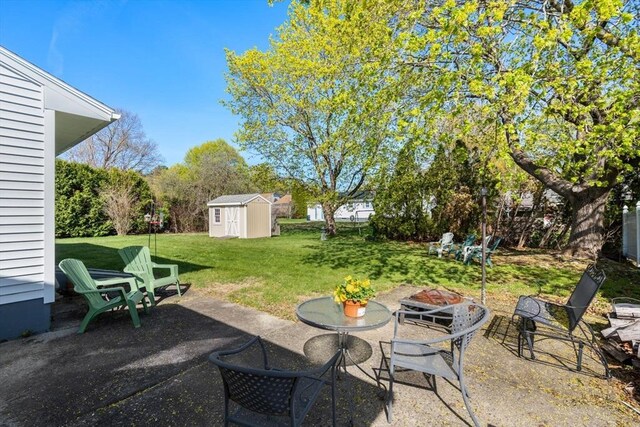 view of patio / terrace with a storage shed, an outbuilding, and an outdoor fire pit