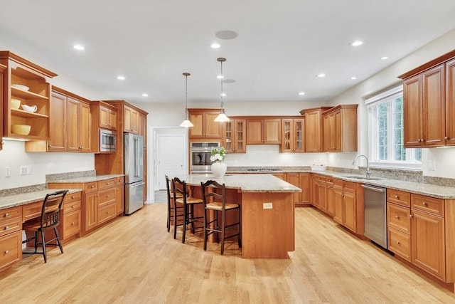 3 Aaron Rd, Lexington, MA 02421 - kitchen with appliances with stainless steel finishes, a center island, a kitchen breakfast bar, brown cabinetry, and recessed lighting