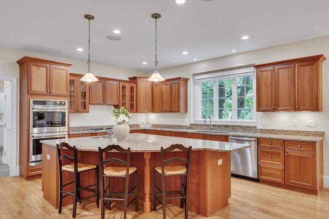 3 Aaron Rd, Lexington, MA 02421 - kitchen with appliances with stainless steel finishes, brown cabinetry, an island with sink, and recessed lighting