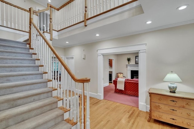 3 Aaron Rd, Lexington, MA 02421 - stairs featuring wood finished floors, crown molding, a fireplace, recessed lighting, and a towering ceiling