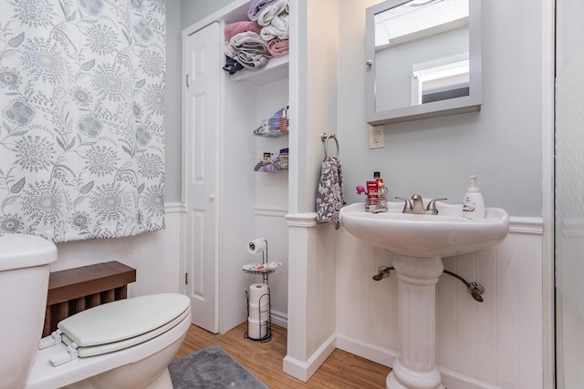 bathroom with toilet and wood finished floors