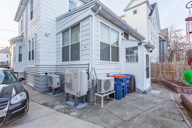 view of home's exterior featuring ac unit and fence