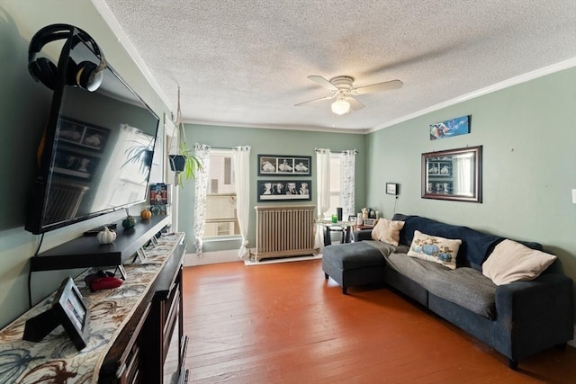 living area featuring a ceiling fan, a textured ceiling, radiator, and ornamental molding