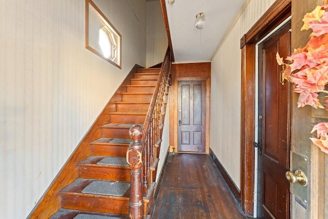 staircase with hardwood / wood-style floors and crown molding