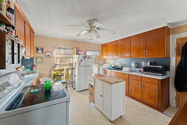 kitchen with crown molding, ceiling fan, white appliances, light floors, and light countertops