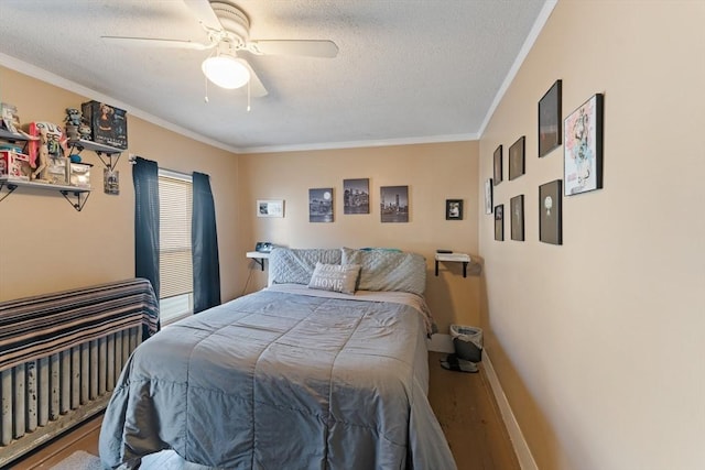 bedroom featuring crown molding, ceiling fan, a textured ceiling, wood finished floors, and baseboards
