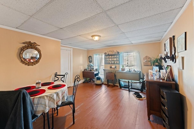 dining space with wood finished floors and a drop ceiling
