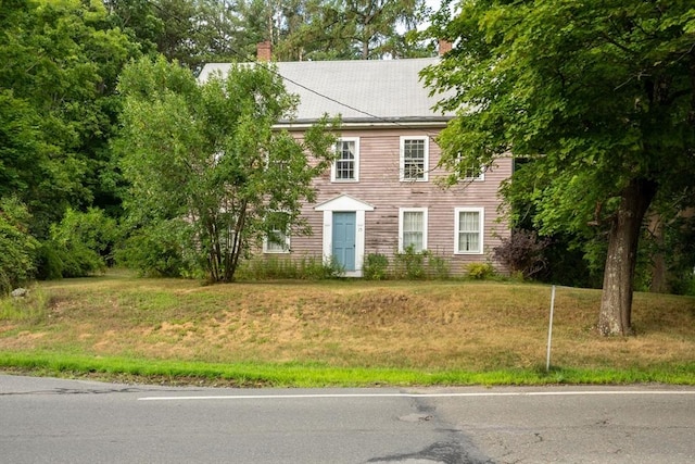 colonial home with a front lawn