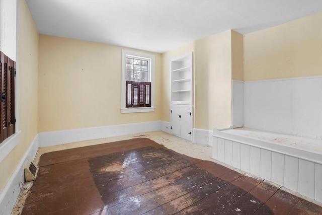 spare room featuring built in shelves