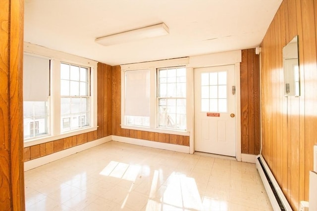 unfurnished sunroom with a wealth of natural light and baseboard heating