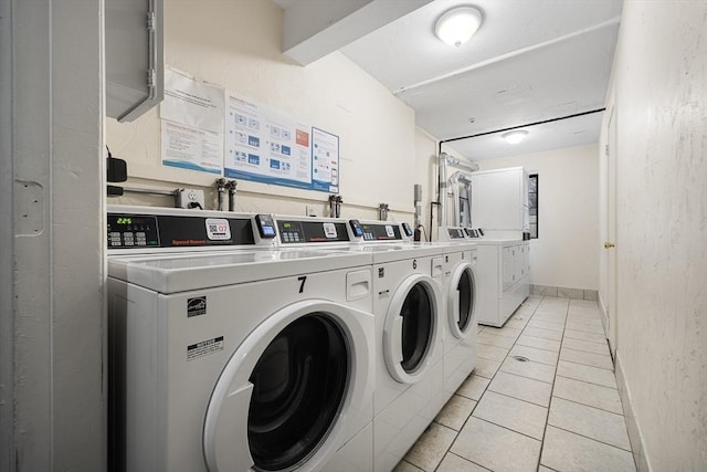 laundry area featuring washing machine and dryer and light tile patterned flooring