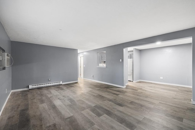 empty room featuring hardwood / wood-style floors and a baseboard radiator