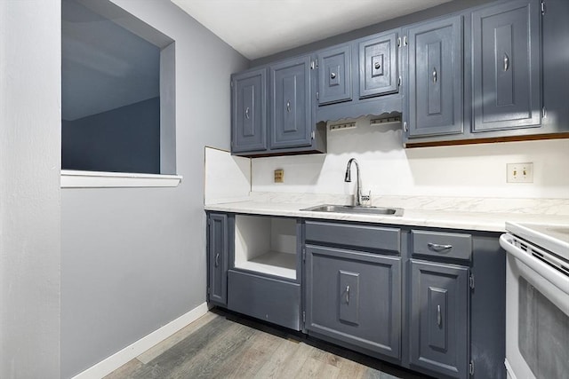 kitchen with gray cabinetry, dark hardwood / wood-style floors, stove, and sink