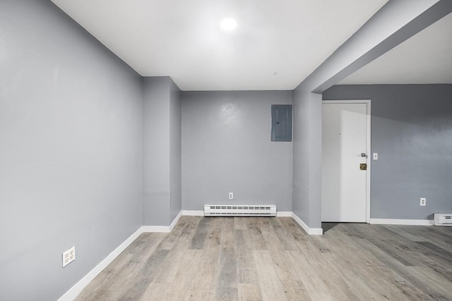 unfurnished room with electric panel, baseboard heating, and light hardwood / wood-style floors