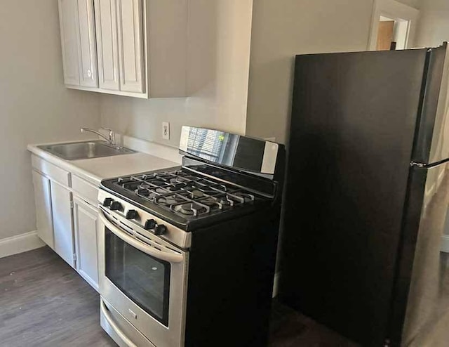 125-129 Arlington St, Chelsea, MA 02150 - kitchen featuring light countertops, appliances with stainless steel finishes, a sink, and white cabinets