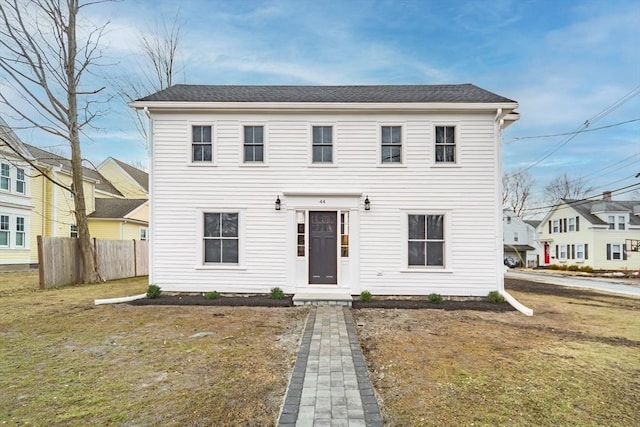 colonial home featuring a residential view, fence, and a front yard