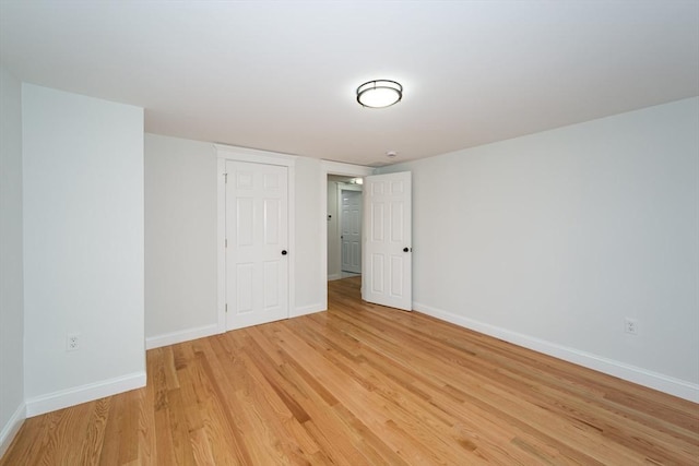 spare room featuring light wood finished floors and baseboards