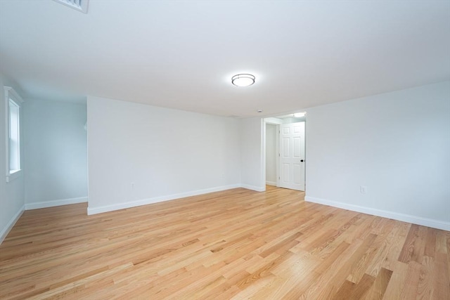 empty room featuring light wood finished floors and baseboards