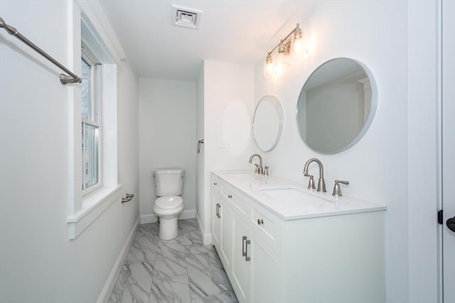 bathroom with toilet, marble finish floor, a sink, and visible vents