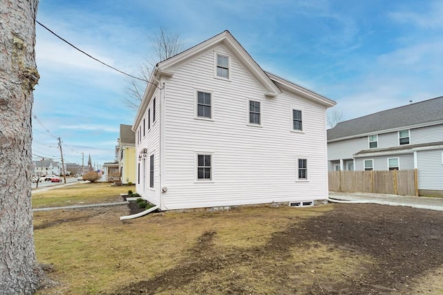 back of house with fence and a lawn