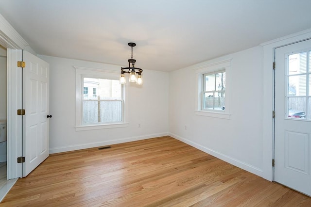 unfurnished dining area featuring a wealth of natural light, light wood-type flooring, visible vents, and baseboards