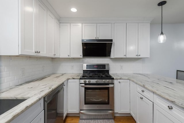 kitchen featuring decorative backsplash, hanging light fixtures, white cabinets, and stainless steel appliances