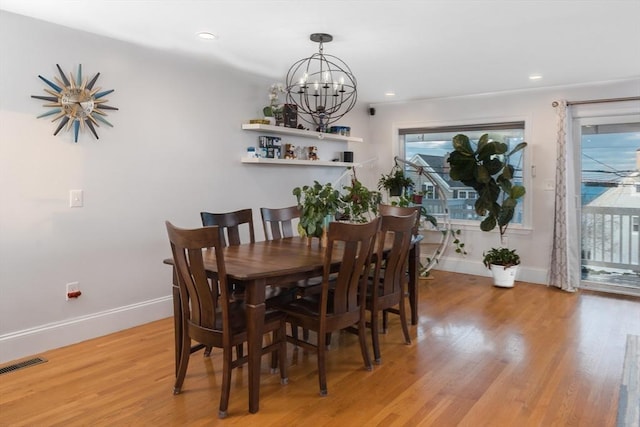 dining space with a chandelier and light hardwood / wood-style floors