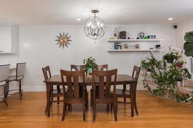 dining space featuring light hardwood / wood-style flooring and a chandelier