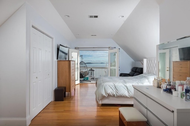 bedroom with access to outside, light hardwood / wood-style floors, and lofted ceiling