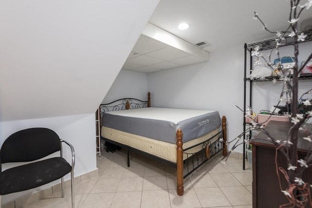 bedroom with light tile patterned floors and a paneled ceiling