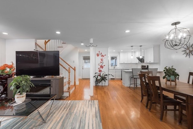 dining space featuring light wood-type flooring and an inviting chandelier