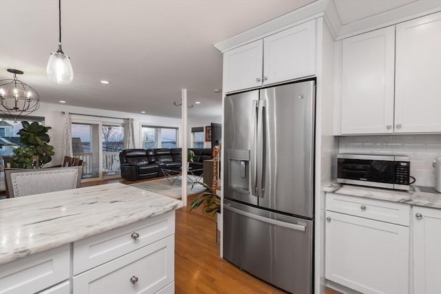 kitchen with white cabinets, appliances with stainless steel finishes, and light wood-type flooring