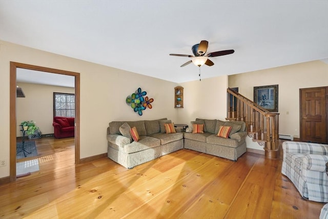 living room with hardwood / wood-style flooring, ceiling fan, and a baseboard heating unit