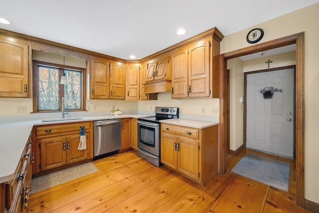 kitchen featuring sink, light wood-type flooring, and appliances with stainless steel finishes