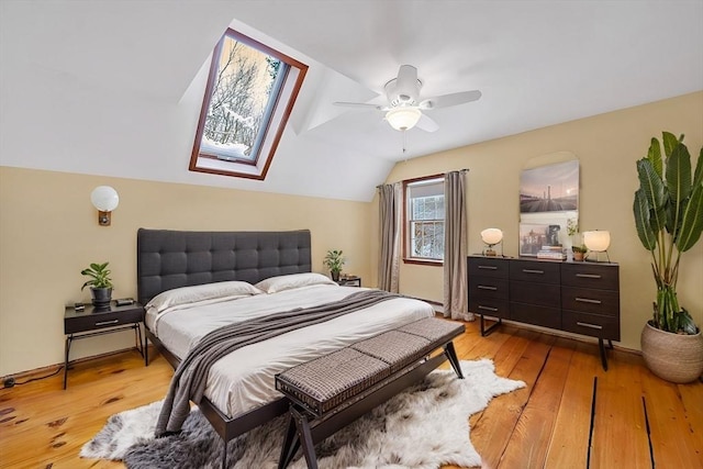 bedroom featuring ceiling fan, light hardwood / wood-style floors, and vaulted ceiling