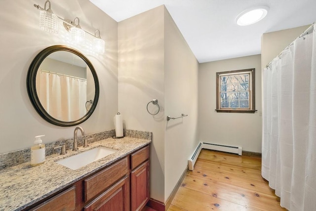 bathroom featuring vanity, hardwood / wood-style floors, and baseboard heating