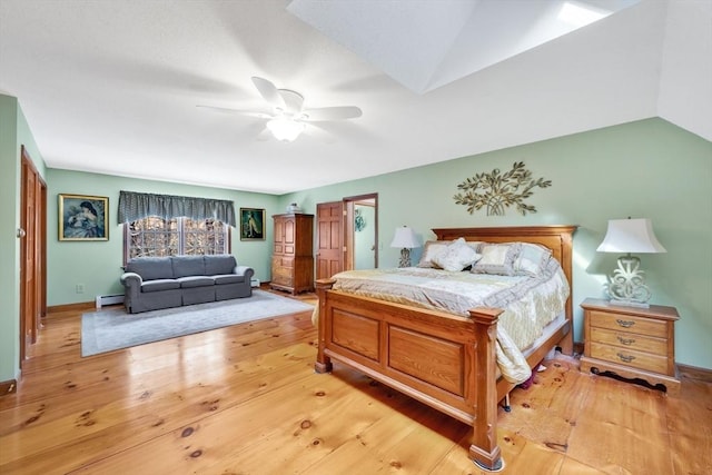 bedroom with ceiling fan, light hardwood / wood-style floors, and a baseboard radiator