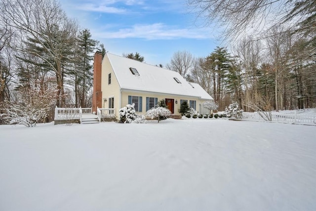 snow covered rear of property with a wooden deck