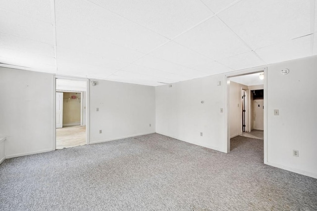 carpeted empty room with a drop ceiling