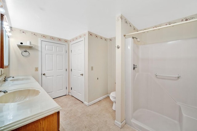 bathroom featuring toilet, a shower, and vanity