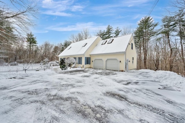 snow covered property with a garage