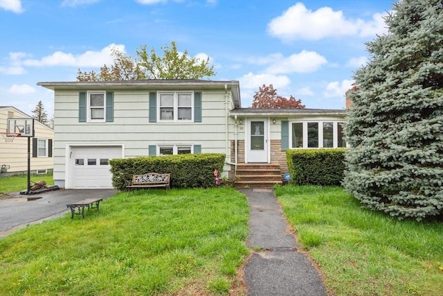 split level home with a garage, driveway, a front yard, and entry steps