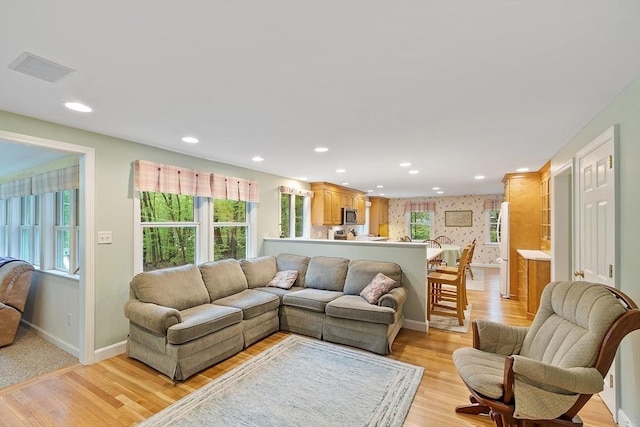 living room featuring light wood-style floors, recessed lighting, and baseboards