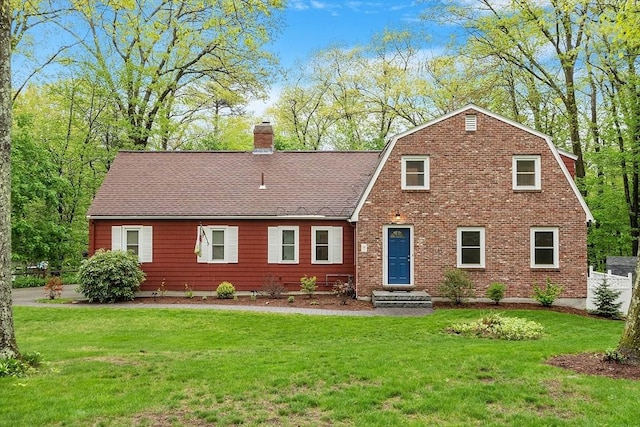 view of front facade featuring a chimney, a front yard, and roof with shingles