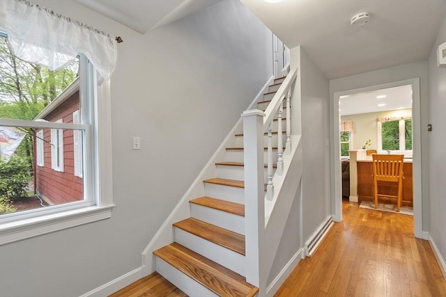 stairs with wood finished floors and baseboards