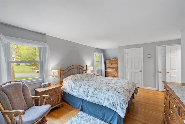 bedroom featuring light wood-style flooring and baseboards