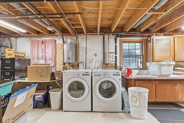 laundry area featuring washer and clothes dryer, tankless water heater, and a sink