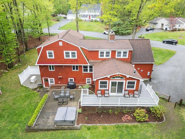 rear view of house featuring a chimney and a deck